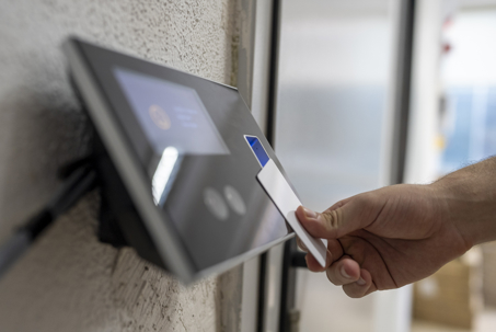 hand swiping key card on access reader